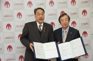 協定書を手にする長尾学長（左）と森田教育長（右）