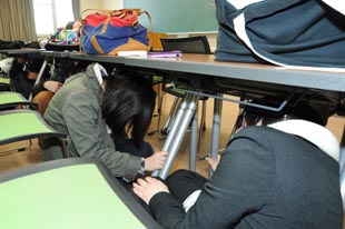 学生が机の下に避難する様子