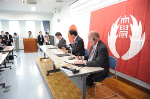 調印書にサインするMax L.Vosskuhler氏（右），長尾彰夫学長（中），藤田大輔教授（左）