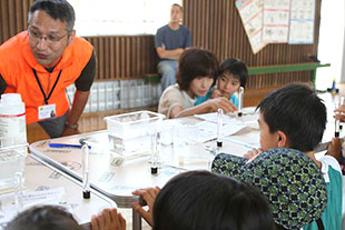 科学教育ボランティア活動での仲矢准教授（写真左）