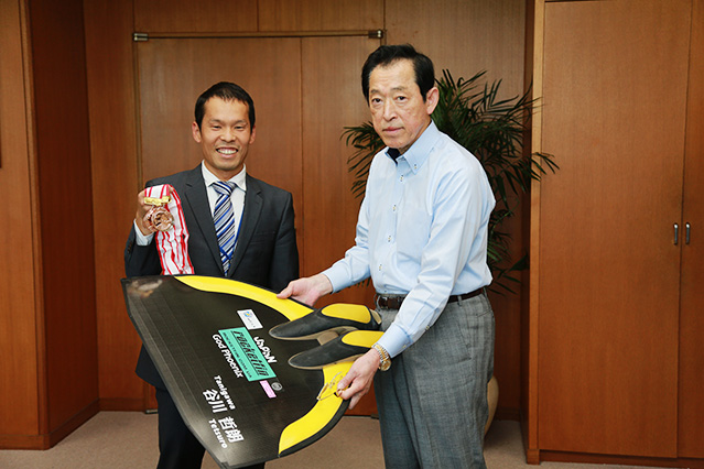 フィンを持つ栗林澄夫学長（右）とメダルを手にする谷川哲朗特任講師（左）