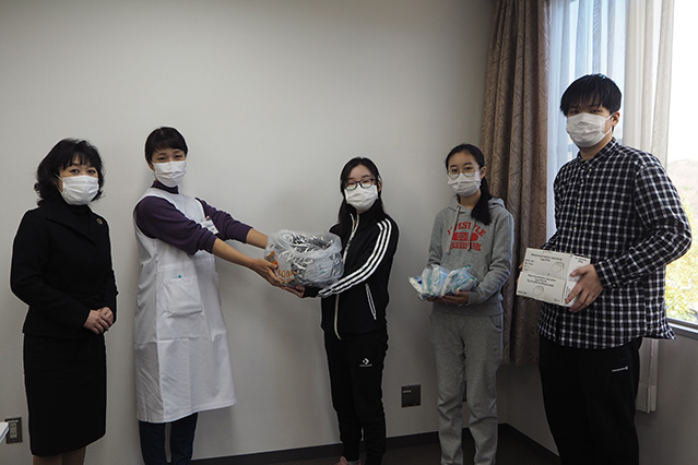 箱﨑センター長, 和田看護師にマスクを手渡す河北師範大学の学生