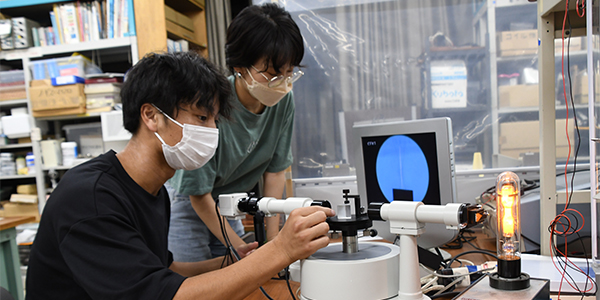プリズム分光計の実験に取り組む2人の学生