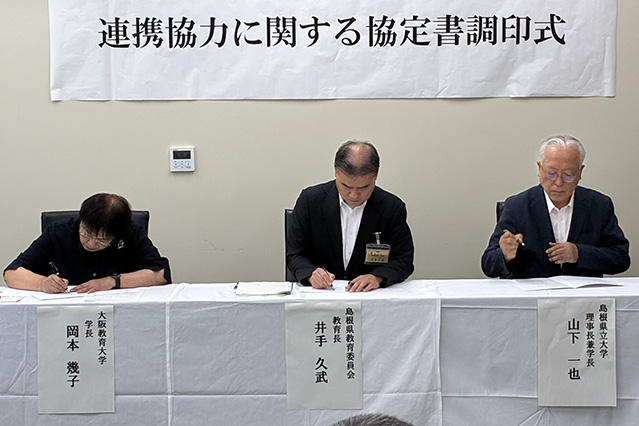 三者による署名が行われる様子